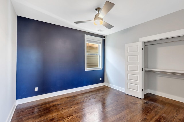 unfurnished bedroom featuring dark hardwood / wood-style floors, ceiling fan, and a closet