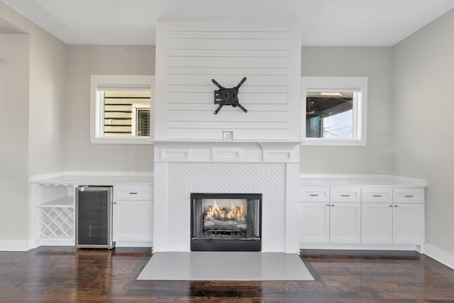 unfurnished living room with wine cooler and dark wood-type flooring