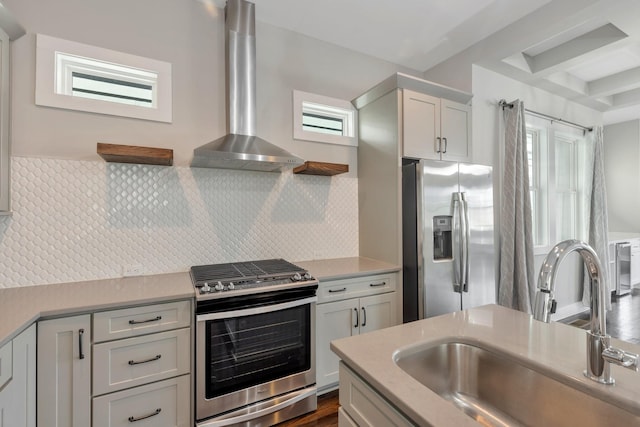 kitchen featuring stainless steel appliances, tasteful backsplash, sink, and wall chimney range hood