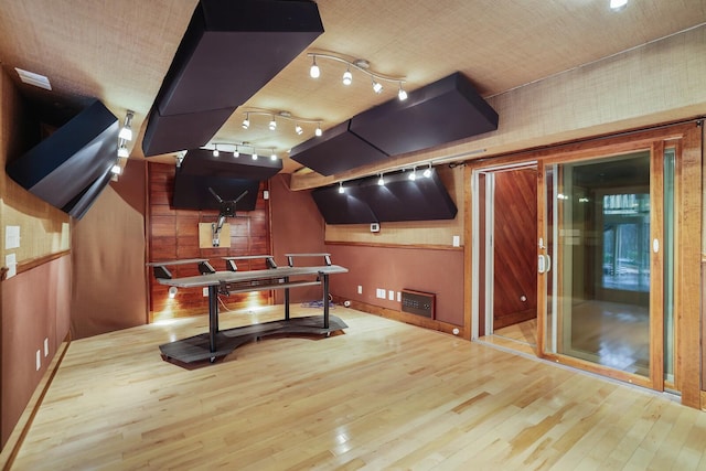 game room with wood-type flooring and rail lighting