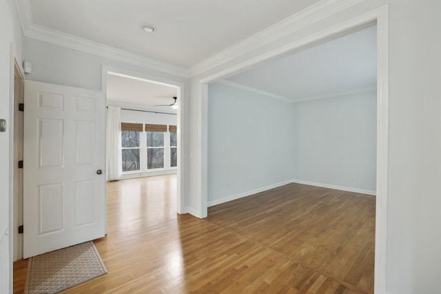 empty room with crown molding and light wood-type flooring