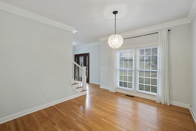 unfurnished dining area with crown molding, a chandelier, and light wood-type flooring