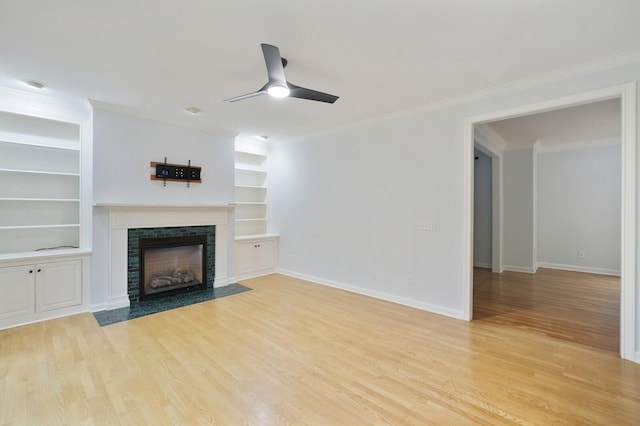 unfurnished living room featuring ornamental molding, ceiling fan, a fireplace, and light hardwood / wood-style flooring