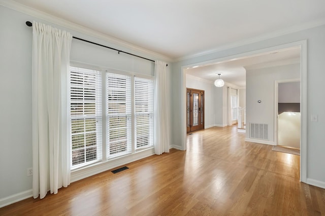 unfurnished room with ornamental molding and light wood-type flooring