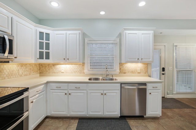 kitchen with white cabinetry, appliances with stainless steel finishes, sink, and tasteful backsplash