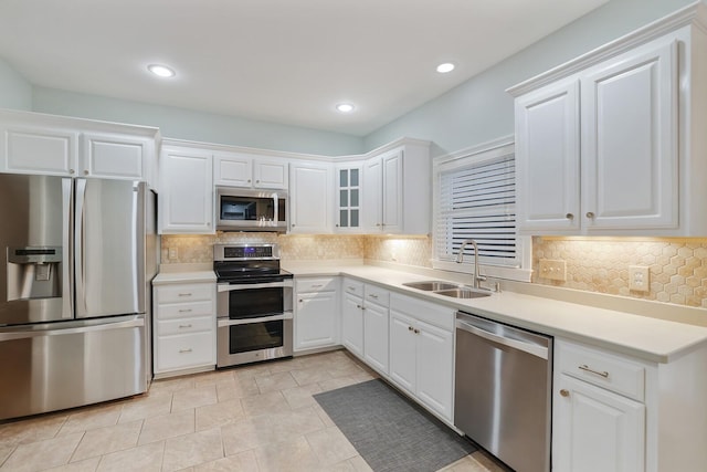 kitchen featuring stainless steel appliances, tasteful backsplash, sink, and white cabinets