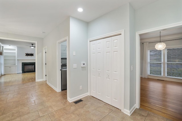 foyer entrance featuring ceiling fan with notable chandelier