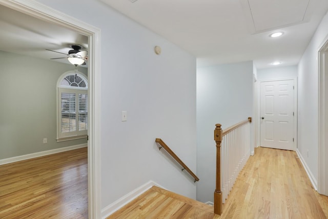 stairway with wood-type flooring and ceiling fan