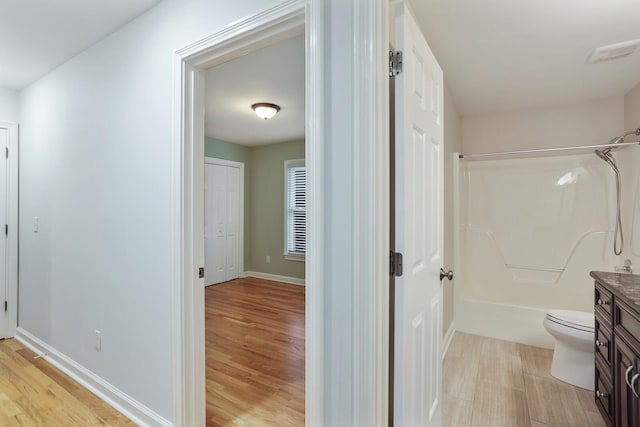 full bathroom featuring vanity, wood-type flooring, bathing tub / shower combination, and toilet