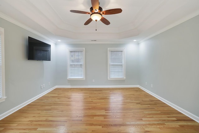 spare room featuring crown molding, light hardwood / wood-style floors, a raised ceiling, and ceiling fan