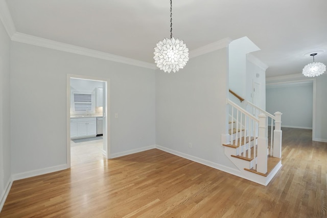 unfurnished room featuring ornamental molding, light wood-type flooring, and an inviting chandelier