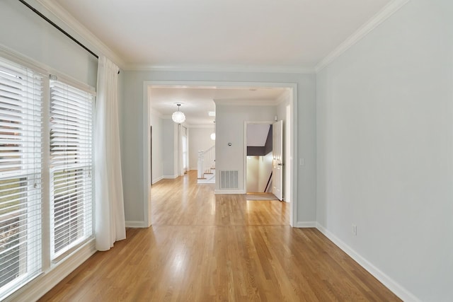 hall with crown molding and light hardwood / wood-style flooring