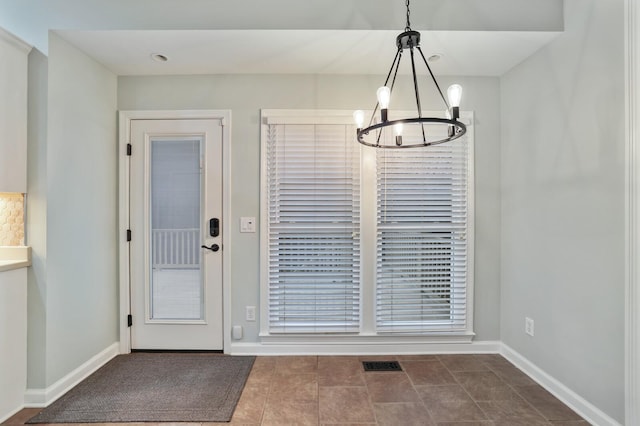 unfurnished dining area featuring a chandelier