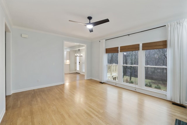 empty room with ceiling fan with notable chandelier, ornamental molding, and light wood-type flooring