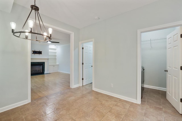 unfurnished dining area featuring built in shelves and a chandelier