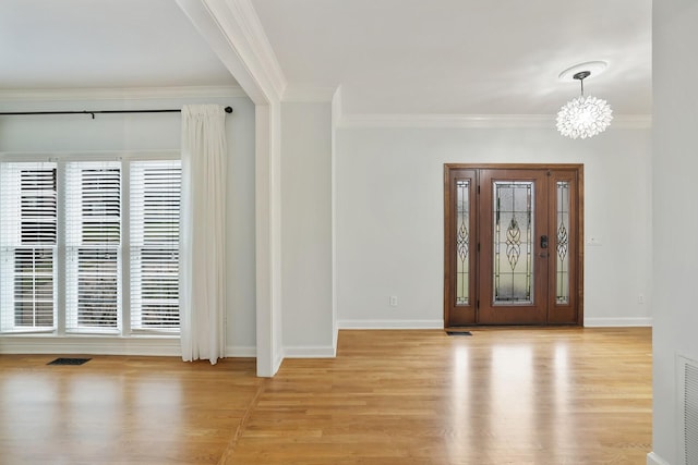 foyer featuring ornamental molding, a chandelier, and light hardwood / wood-style floors