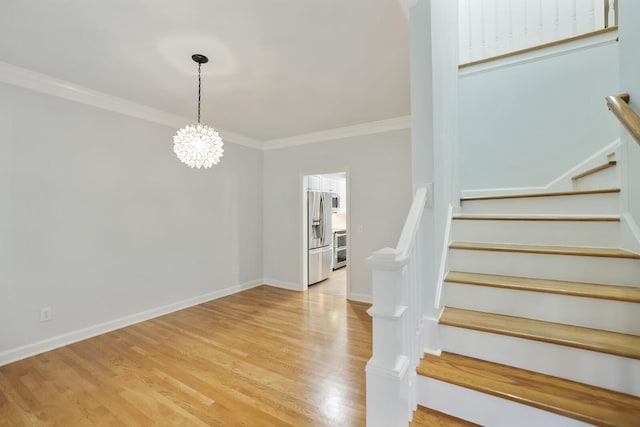 stairway with hardwood / wood-style flooring, crown molding, and a notable chandelier