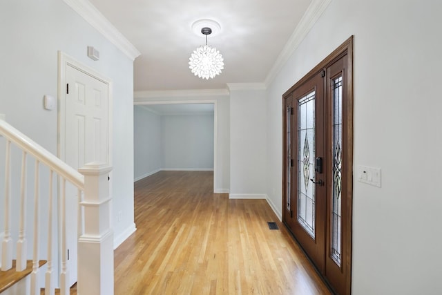 entrance foyer with crown molding, a notable chandelier, and light wood-type flooring