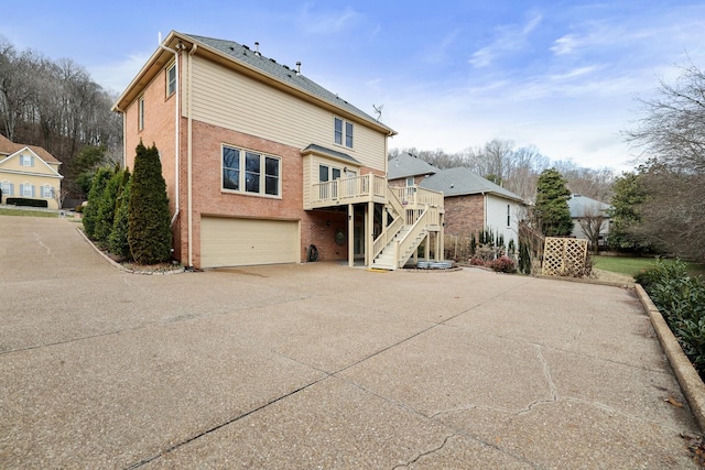 back of property featuring a garage and a deck