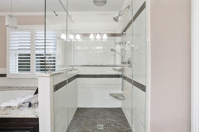 bathroom with ornamental molding and shower with separate bathtub