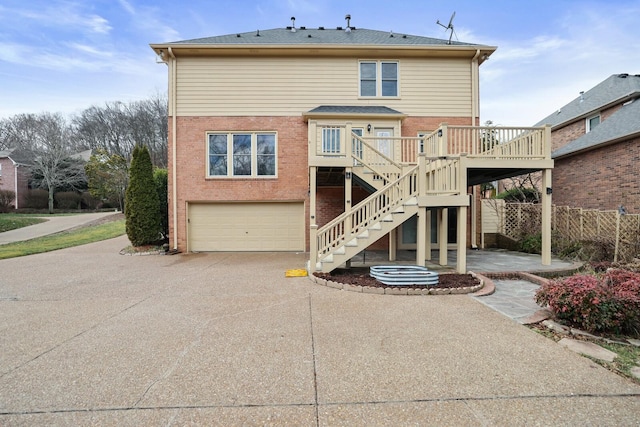 rear view of house featuring a garage and a wooden deck