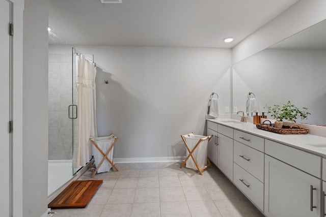 bathroom with a shower with door, vanity, and tile patterned floors