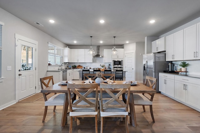 dining area with light wood finished floors, visible vents, and recessed lighting