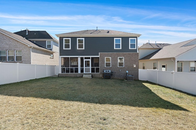 rear view of house featuring cooling unit, a fenced backyard, a sunroom, a yard, and a residential view