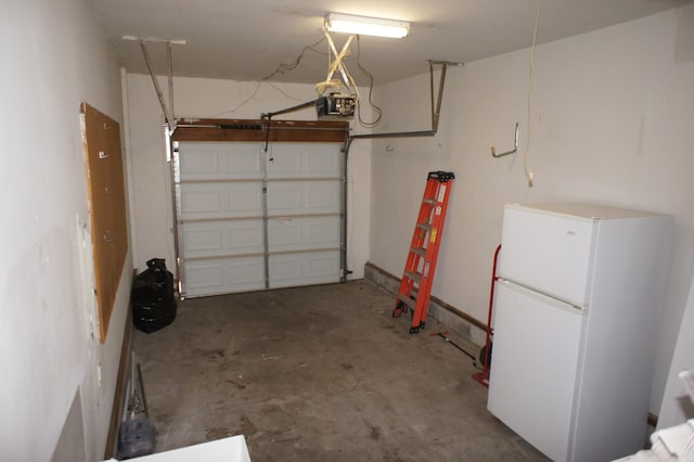 garage featuring white refrigerator and a garage door opener