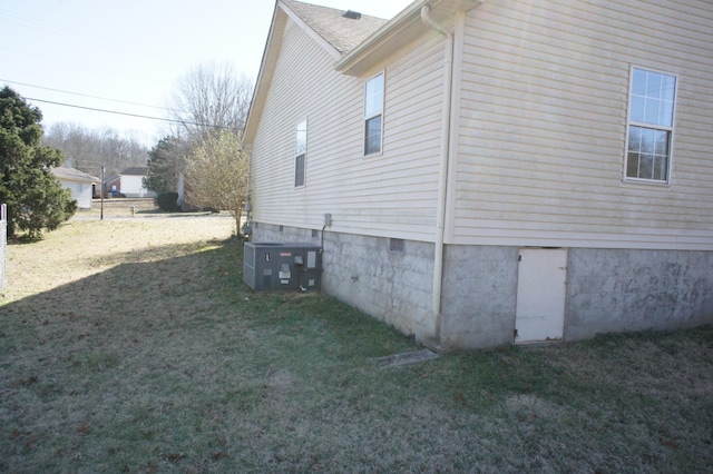 view of home's exterior with a yard and central AC unit