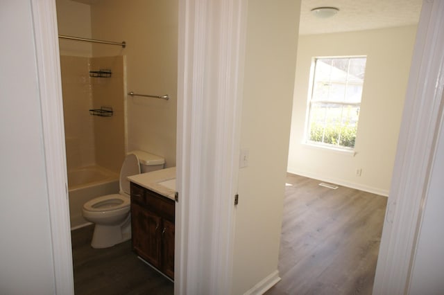 full bathroom with wood-type flooring, tub / shower combination, vanity, and toilet