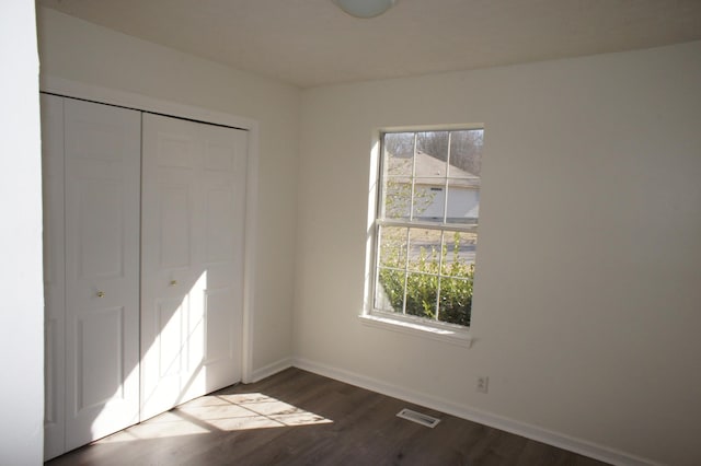 unfurnished bedroom with hardwood / wood-style flooring and a closet