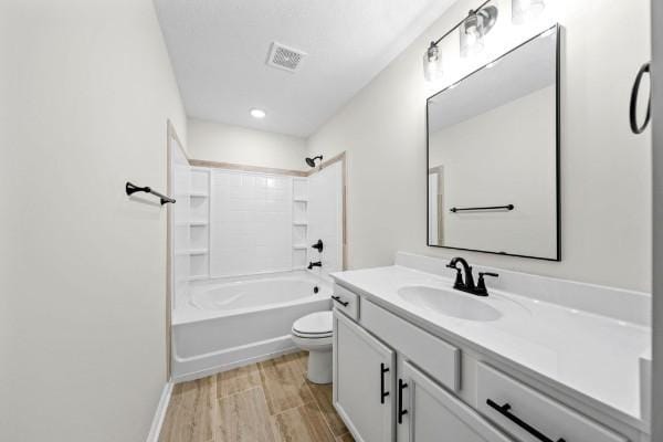 full bathroom with vanity, hardwood / wood-style flooring, bathing tub / shower combination, and toilet