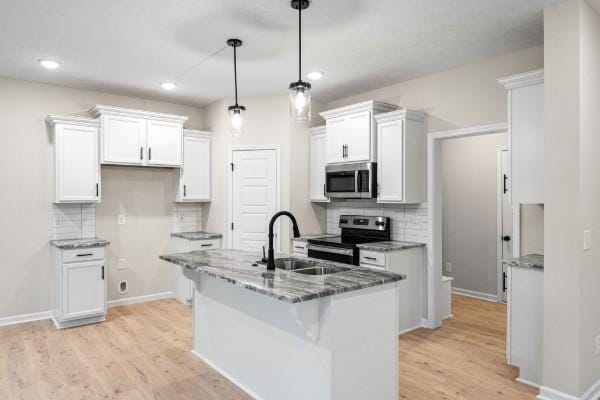 kitchen with white cabinetry, stainless steel appliances, decorative light fixtures, and sink