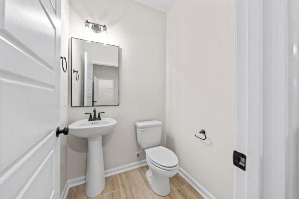 bathroom featuring sink, hardwood / wood-style floors, and toilet