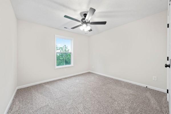 carpeted empty room with ceiling fan