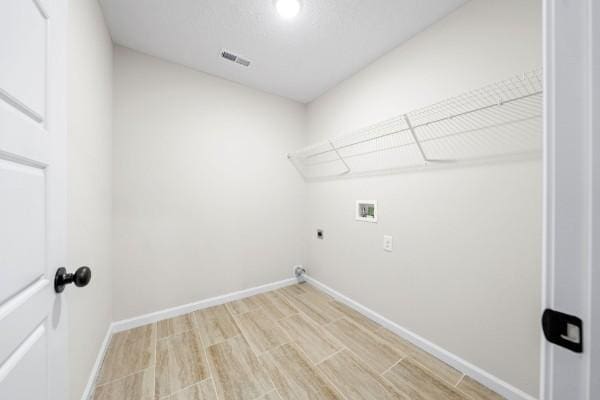 laundry room featuring hookup for a washing machine, light hardwood / wood-style flooring, and electric dryer hookup