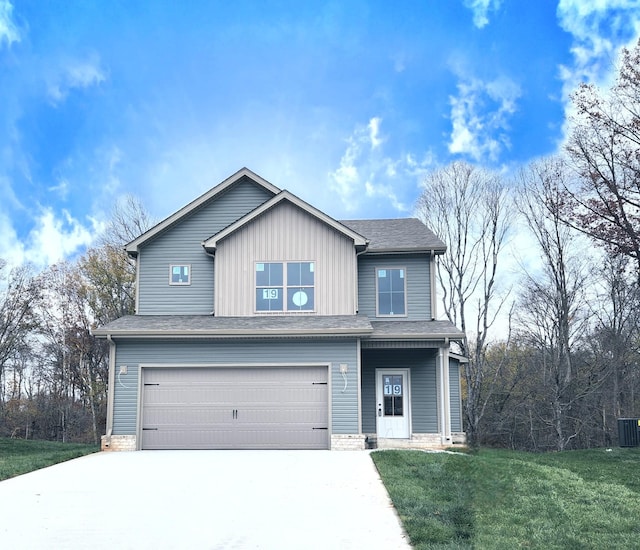 view of front of house featuring a garage, a front yard, and central AC unit