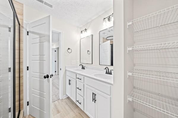 bathroom with hardwood / wood-style flooring, vanity, and a textured ceiling