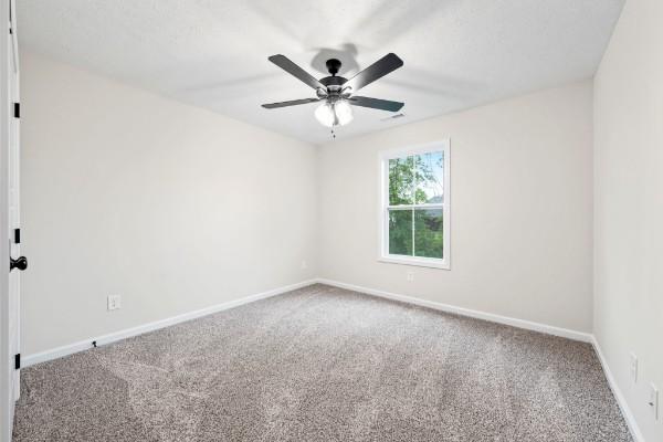 carpeted empty room featuring ceiling fan