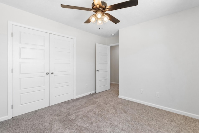 unfurnished bedroom featuring ceiling fan, a closet, and light carpet