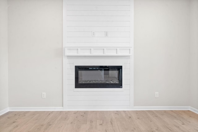 details with a large fireplace and hardwood / wood-style floors