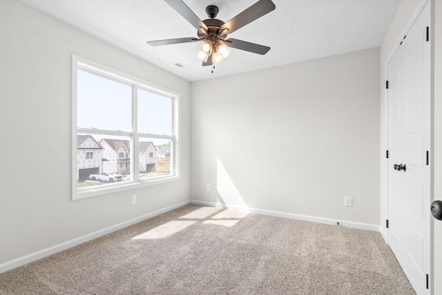 unfurnished room with ceiling fan and carpet