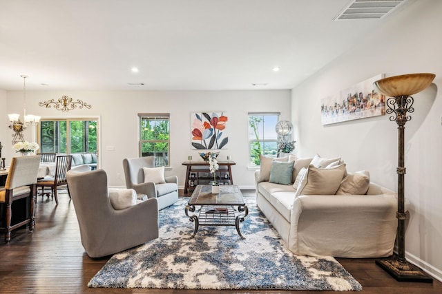 living room with dark hardwood / wood-style flooring and a chandelier