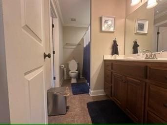 bathroom with vanity, crown molding, and toilet