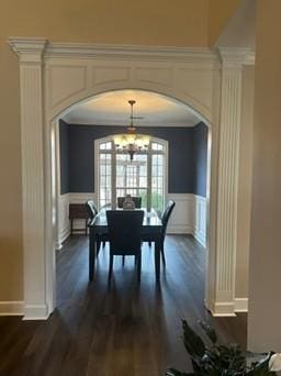 dining room featuring dark wood-type flooring, ornamental molding, and an inviting chandelier