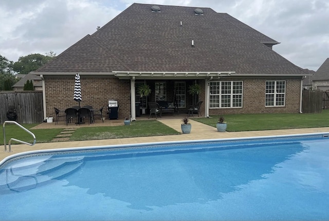 view of swimming pool with an outdoor bar, a patio area, grilling area, and a lawn