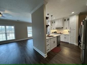 kitchen with appliances with stainless steel finishes, decorative light fixtures, white cabinetry, crown molding, and dark wood-type flooring