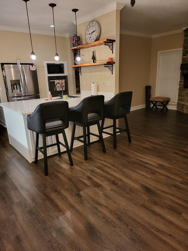 kitchen featuring a kitchen bar, hanging light fixtures, ornamental molding, dark hardwood / wood-style floors, and black appliances