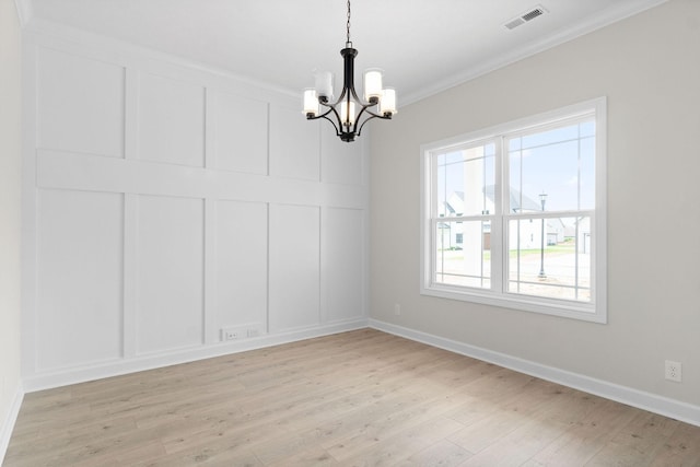 unfurnished room featuring crown molding, an inviting chandelier, and light hardwood / wood-style floors